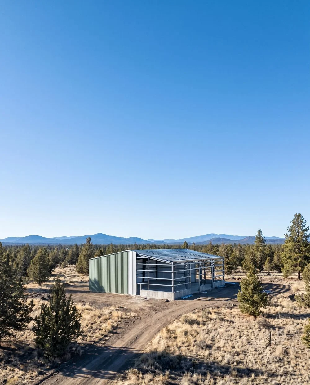 A steel building part way through erection standing alone in an enormous empty western landscape